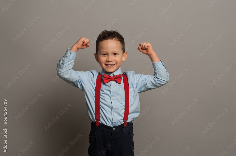 Happy boy laughs funny, screams in surprise, raising his hands up, the concept of childrens emotions Happy boy laughs funny, screams in surprise, raising his hands up, the concept of childrens emotions