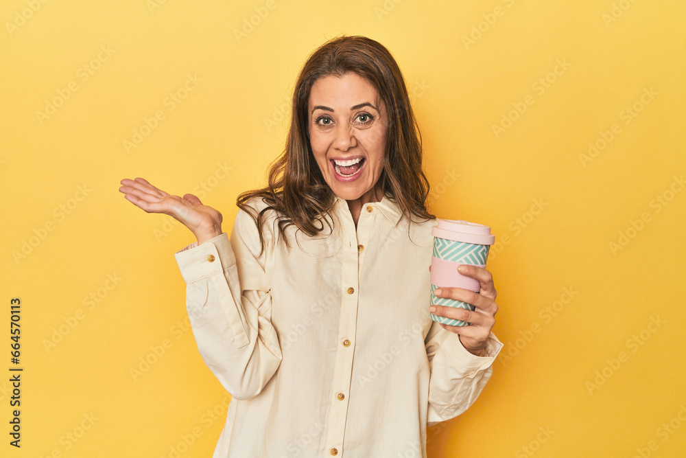 Woman sipping takeaway coffee on yellow background Woman sipping takeaway coffee on yellow background