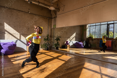 A girl dances a contemporary dance in a sunlit studio © Дмитро Петрина