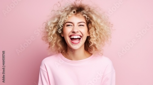 A young caucasian woman, isolated on a pink background, exuding a jubilant vibe with a wide smile, embodying the spirit of youthful exuberance.