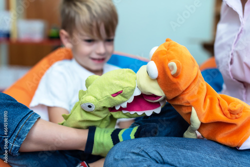 Little boy and speech therapist using colorful toys on session. Friendly child psychologist during play therapy with preschooler. Mom or teacher and boy learn pronouncing sounds. kids theatre