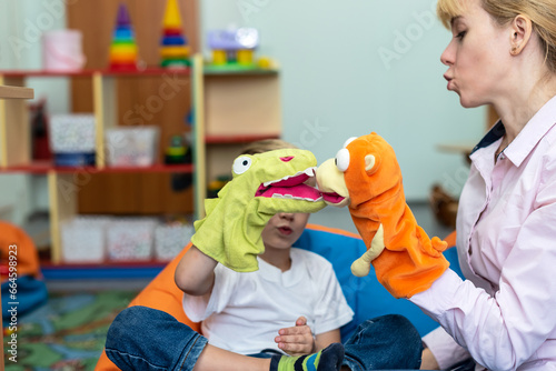 Little boy and speech therapist using colorful toys on session. Friendly child psychologist during play therapy with preschooler. Mom or teacher and boy learn pronouncing sounds. kids theatre