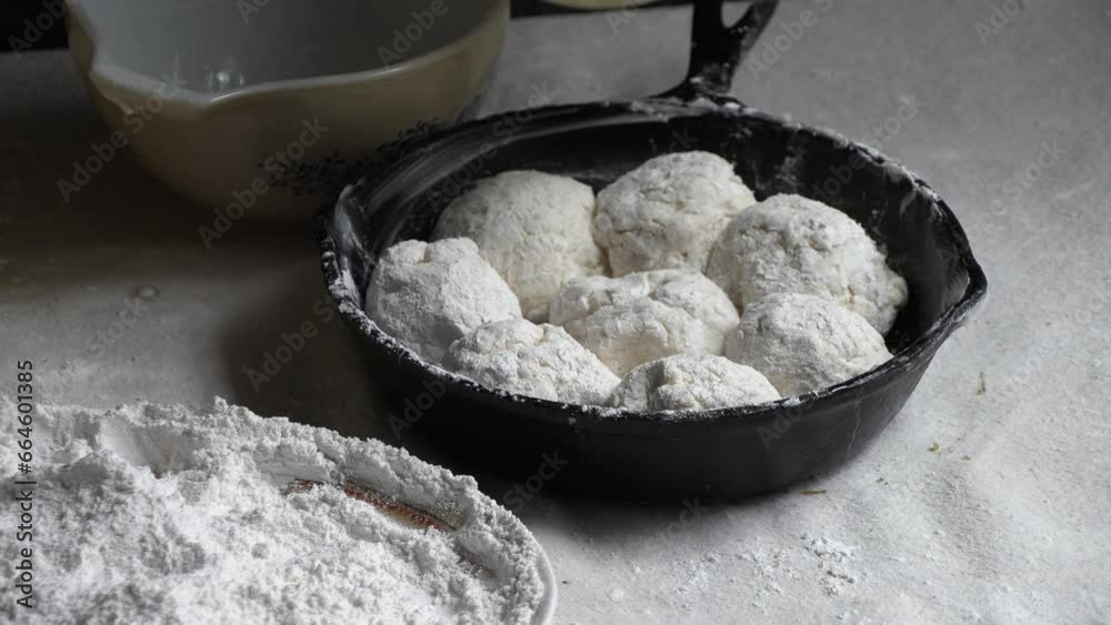Southern biscuits being buttered in a cast iron skillet,pan