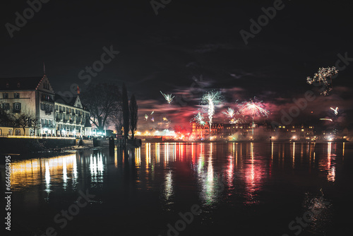 New Year's Eve midnight fireworks over the promenade of Peterhausen, taken from the waterfront next to the Steigenberger Hotel. Constance (Konstanz), Lake Constance, Baden-Württemberg, Germany. photo