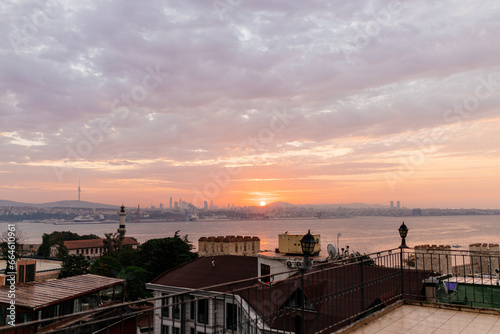 Beautiful landscape with sunrise over the city roofs, the bay and the city in the background. Dawn from the roofs of Istanbul overlooking the Bosphorus. Istanbul, Türkiye - October 16, 2023 © Liudmila
