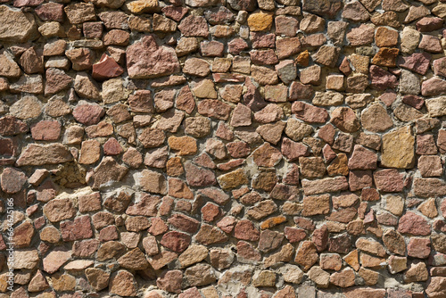Texture of a stone wall made of red stone.