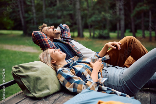 Happy couple of campers enjoying in freedom and fresh air in woods. photo