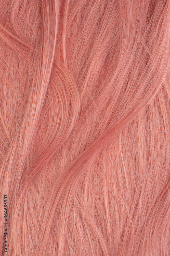 Fototapeta premium Beautifully laid light pink wavy shiny curls close-up as a background
