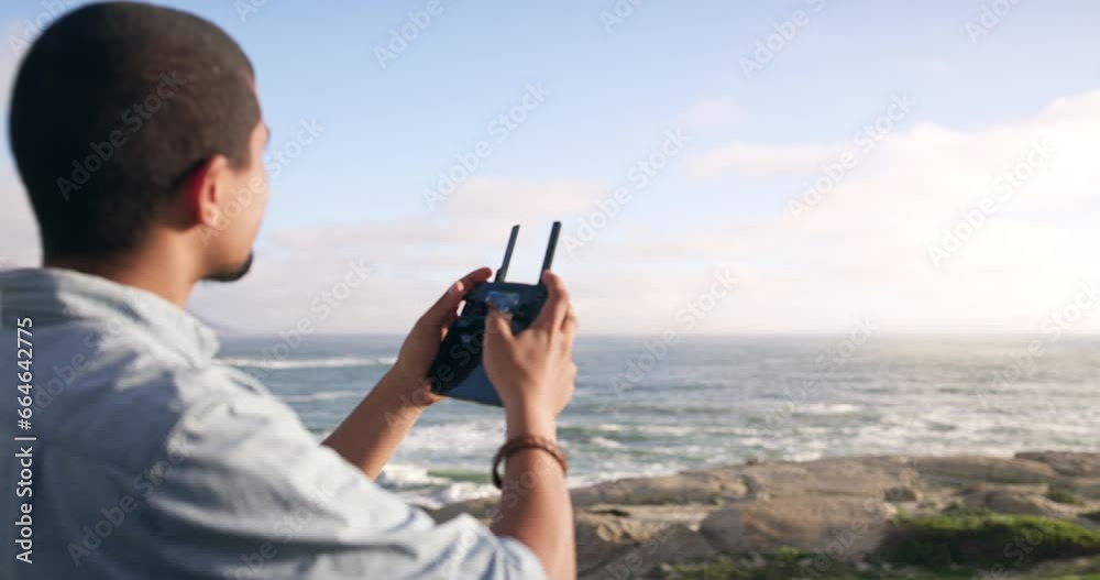 Beach, flight and man pilot drone outdoor at the ocean in summer to travel in nature. Technology, back and person control at sea, robot and quadcopter on adventure, holiday or film on vacation