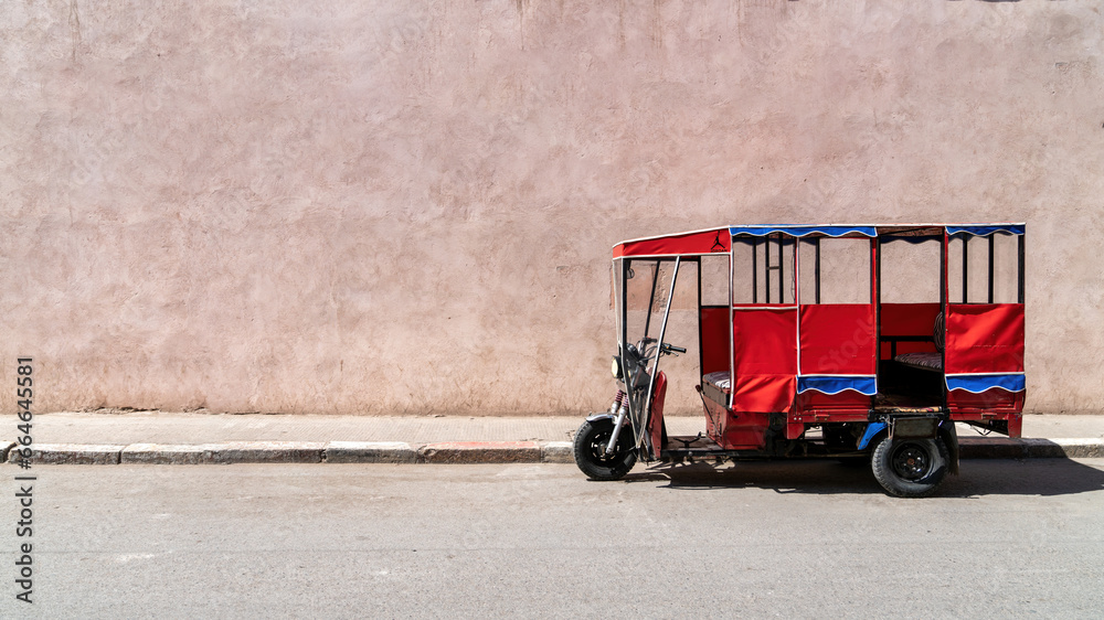 Tok tok vehicle parked in the old city of Marrakesh, Morocco. These tricycle vehicles are used mostly for tourism and public transportation purposes - obrazy, fototapety, plakaty 