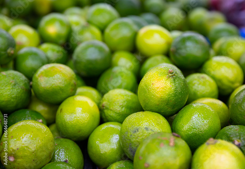 Fresh organic limes displayed in box for sale at farmers market