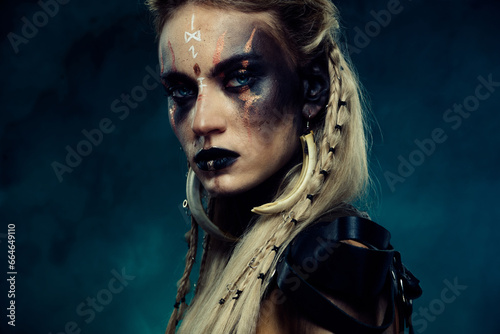 Close up photo of powerful viking queen princess with scar experienced fighter in north war over dark background photo