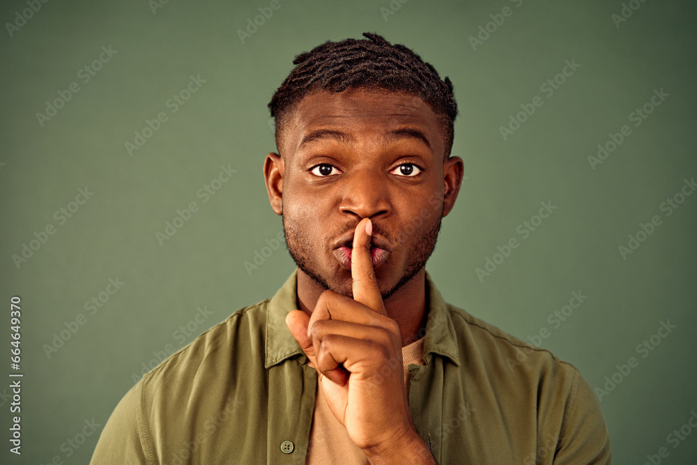 Keep my secret. Portrait of serious young man with afro hairstyle doing