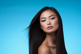 Elegant Asian Woman, Silky Hair on Blue Background. beauty products, shampoo and cosmetics