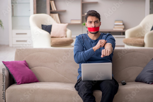 Mouth closed young man working from home