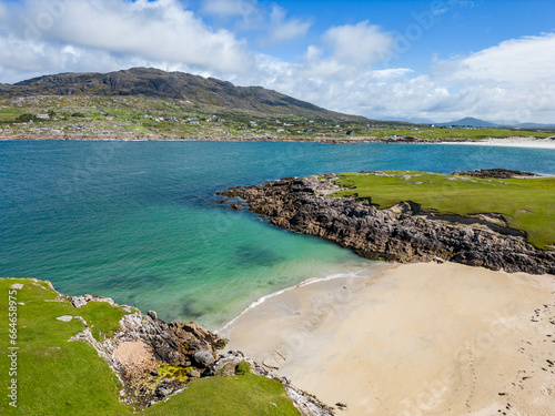 Beach with grass, rocks and sand photo