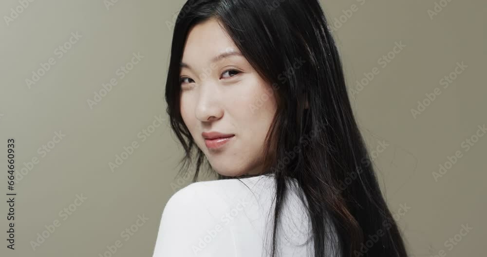 Asian woman with black hair and make up smiling, copy space, slow motion Asian woman with black hair and make up smiling, copy space, slow motion