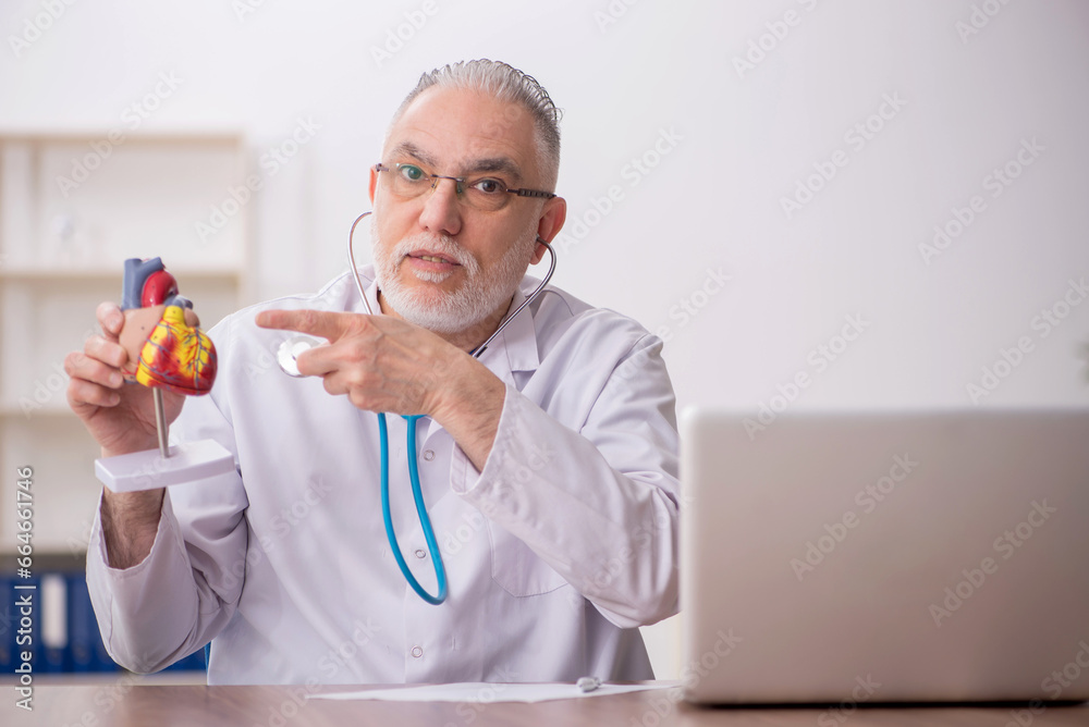 Old male doctor cardiologist working in the clinic Old male doctor cardiologist working in the clinic