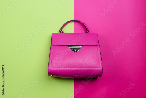 Принти на полотні Modern female top-handle bag in fuchsia leather with a black trim accent, a silver metal detail, and feet isolated on a bright contrasting background with copy space