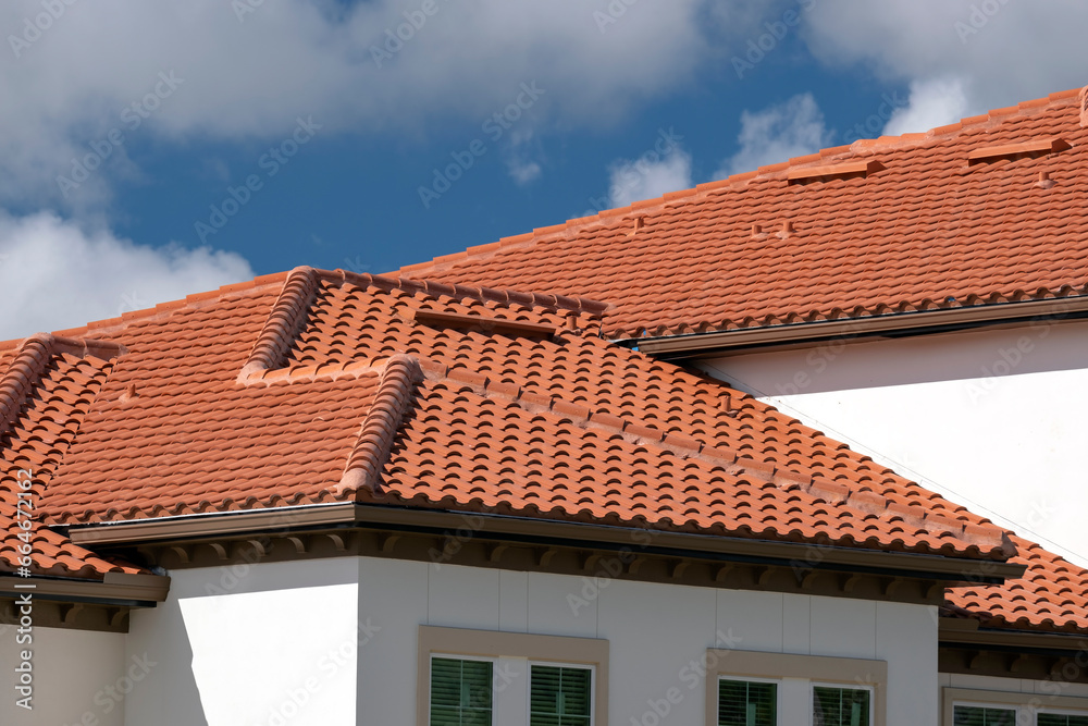 Closeup of house rooftop covered with ceramic shingles. Tiled covering of building