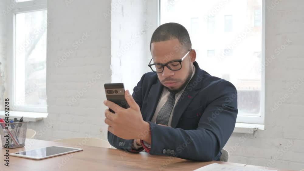 Mixed Race Businessman Shocked by Loss on Phone in Office Mixed Race Businessman Shocked by Loss on Phone in Office