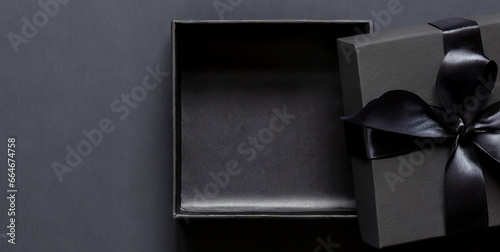 blank open black present box or top view of black gift box with black ribbons and bow isolat