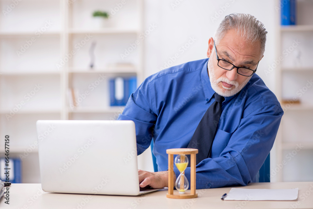Old male employee in time management concept Old male employee in time management concept