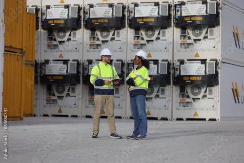 Fotografia At the container yards, two maintenance engineers inspected the compressor of th