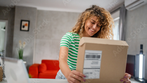 one happy woman open mail cardboard package box present at home
