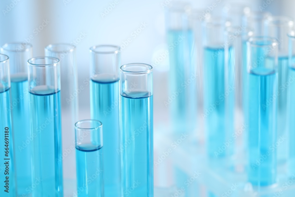 Test tubes with light blue liquid in laboratory, closeup. Space for text Test tubes with light blue liquid in laboratory, closeup. Space for text