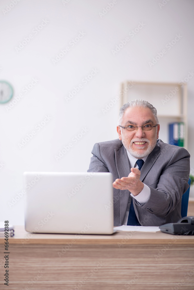 Old male employee working in the office Old male employee working in the office