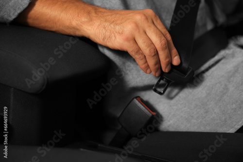 Man fastening safety seat belt in car, closeup © New Africa