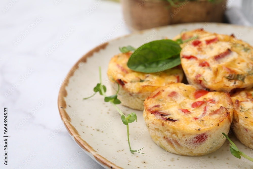 Freshly baked bacon and egg muffins with cheese on light table, closeup