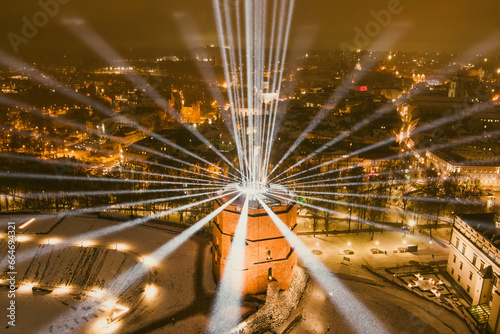 Scenic aerial view of Gediminas tower in Vilnius Old Town beautifully illuminated for 700th birthday celebration. Main symbol of Lithuanian capital at night.