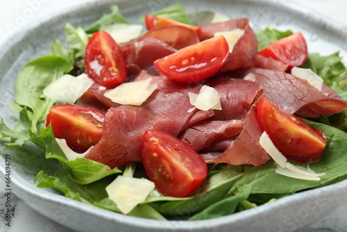 Delicious bresaola salad with tomatoes and parmesan cheese on table, closeup