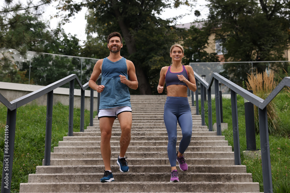 Healthy lifestyle. Happy couple running down stairs outdoors