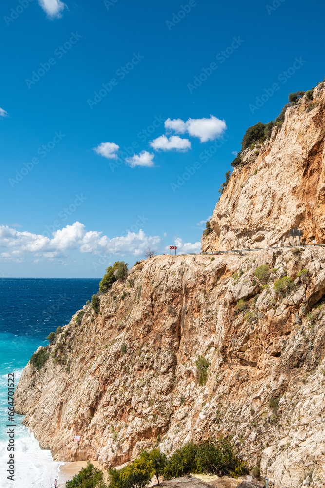 Sheer cliff with a road cut through on the Mediterranean coastline between Kas and Kalkan in Turkey.