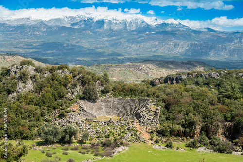 Fotografie, Obraz Landscape at Pinara ancient site in Mugla province of Turkey with a ruined amphitheatre and snow-covered mountains in the background