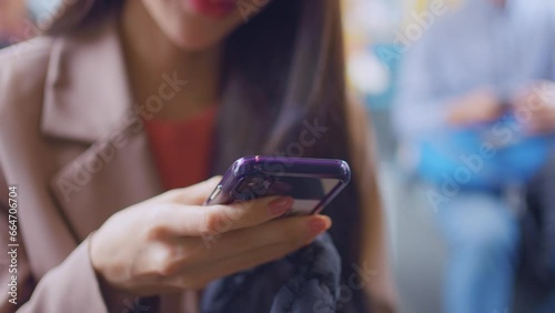 Close up of woman traveler using mobile phone while riding on the train.