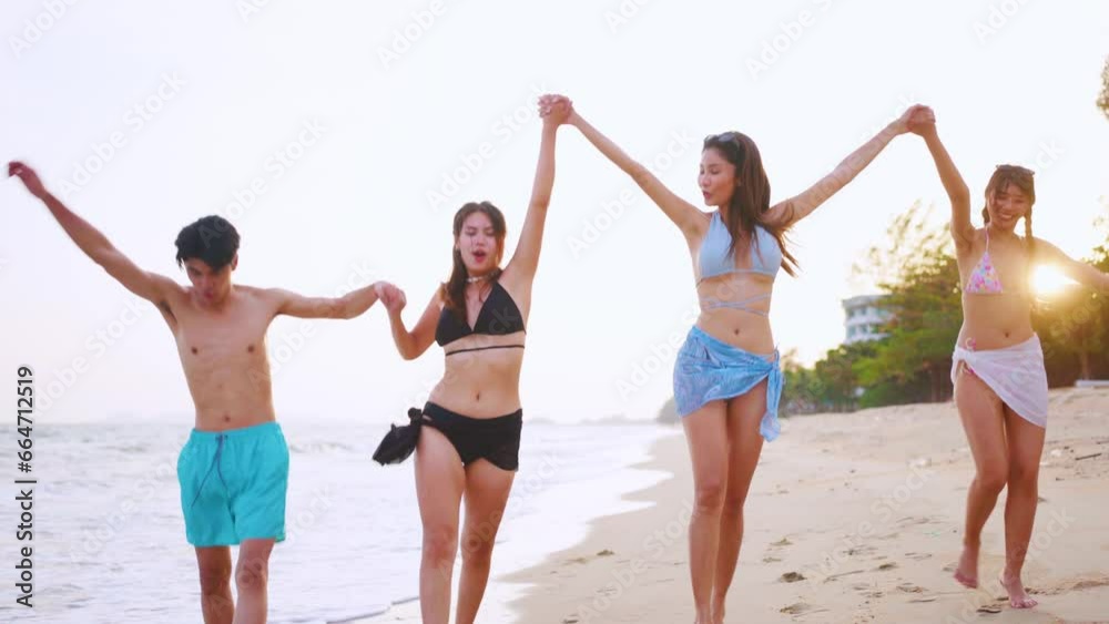 Group of Asian man and woman running on the beach during summer time. Group of Asian man and woman running on the beach during summer time.