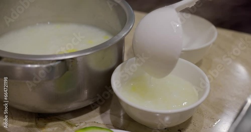 Pour rice congee into a bowl in chinese cuisine photo