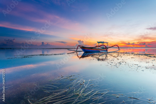 Morning sun in Bali, Indonesia. Traditional fishing boats at Sanur beach, Bali, Indonesia. photo