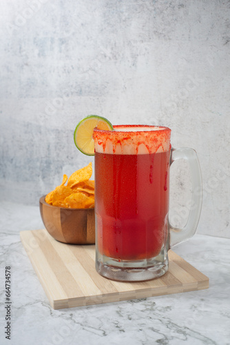 Michelada, Mexican beer drink with chamoy and clamato, with french fries on a white background without people photo