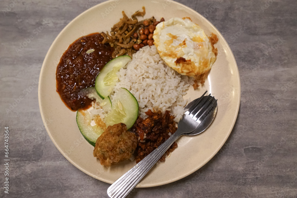 Nasi lemak, a Malay style complete meal of fragrant rice cooked in coconut milk and eaten together with chili paste, fried chicken, hard boiled egg, anchovies and cucumber