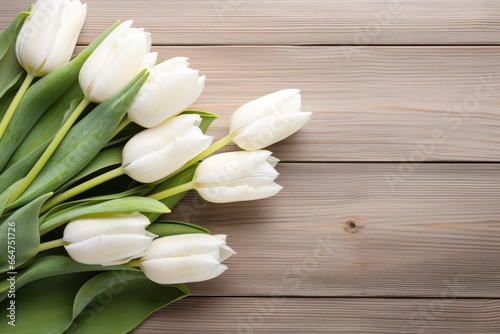 White tulips on wood table.