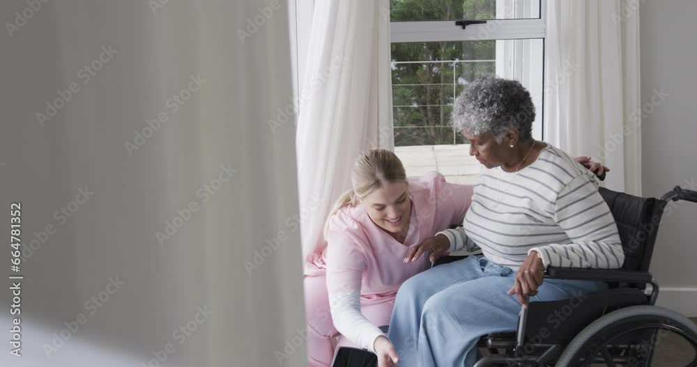 Smiling caucasian nurse with senior african american woman patient in wheelchair, slow motion Smiling caucasian nurse with senior african american woman patient in wheelchair, slow motion