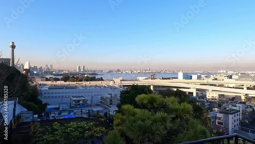 Panoramic view over Cityscape of Minatomirai, Yokohama, Kanagawa Prefecture, Japan. calm evening light blue sky soft blue water. Indstrial port area with yokohama Bay Bridge photo