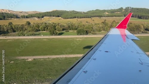 Airplane’s right wing and shadow approaching to the runway in a sunny afternoon. Madrid airport. photo