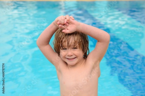 A little boy learns to swim in the pool. Child in swimming pool floating on inflatable mattress. Kids swim. Kid l having fun on family summer vacation in resort