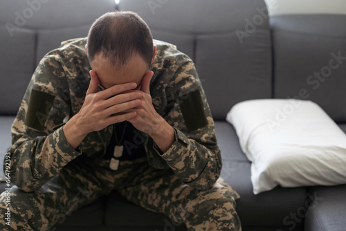 Nervous male military suffering depression, sitting alone at home, PTSD concept © Angelov